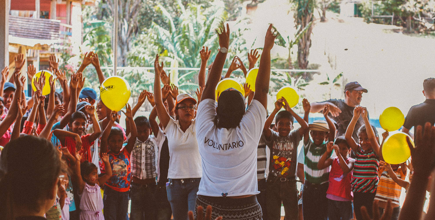 Voluntarios y niños con globos durante una jornada de la fundación