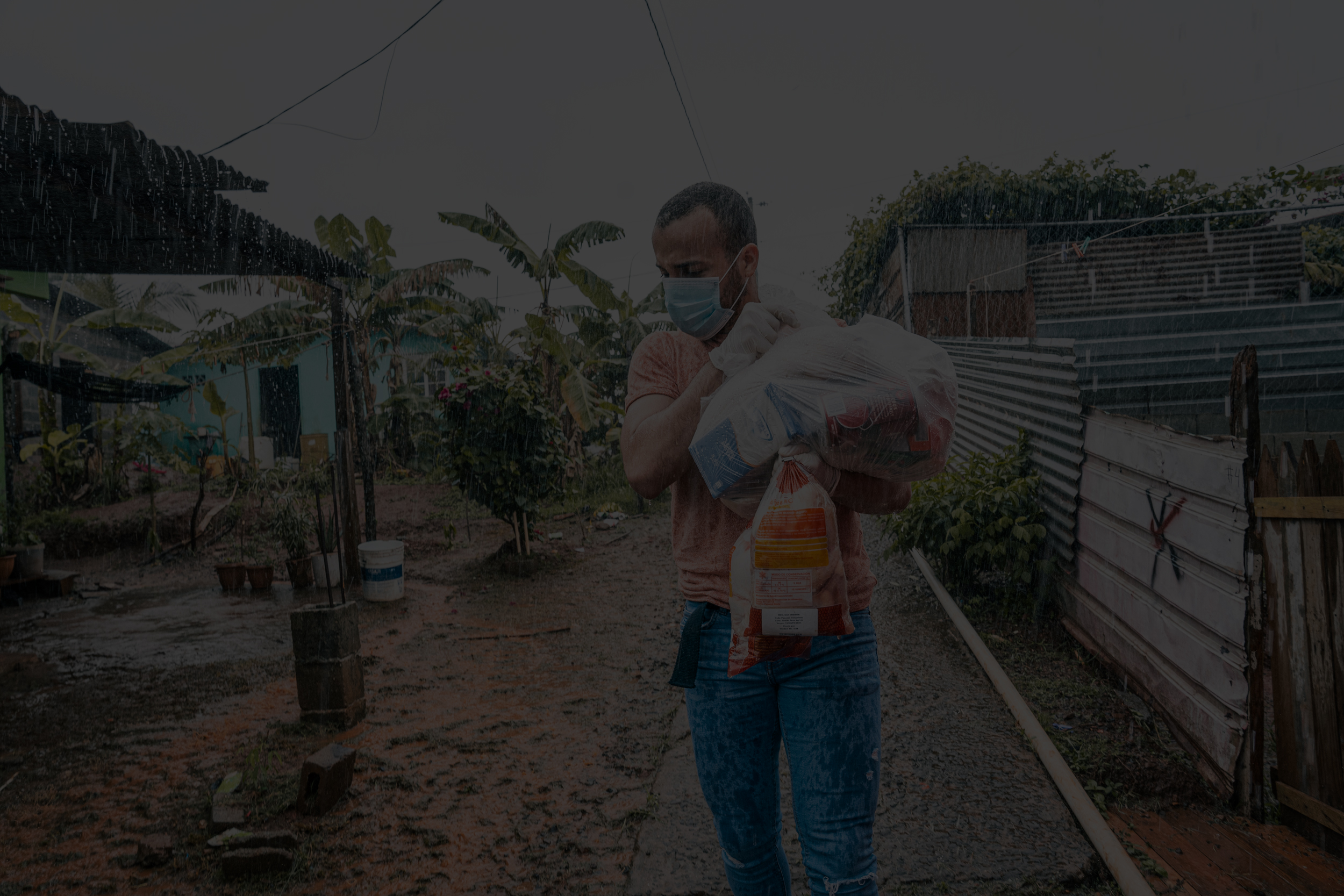 Voluntario entregando suministros bajo la lluvia