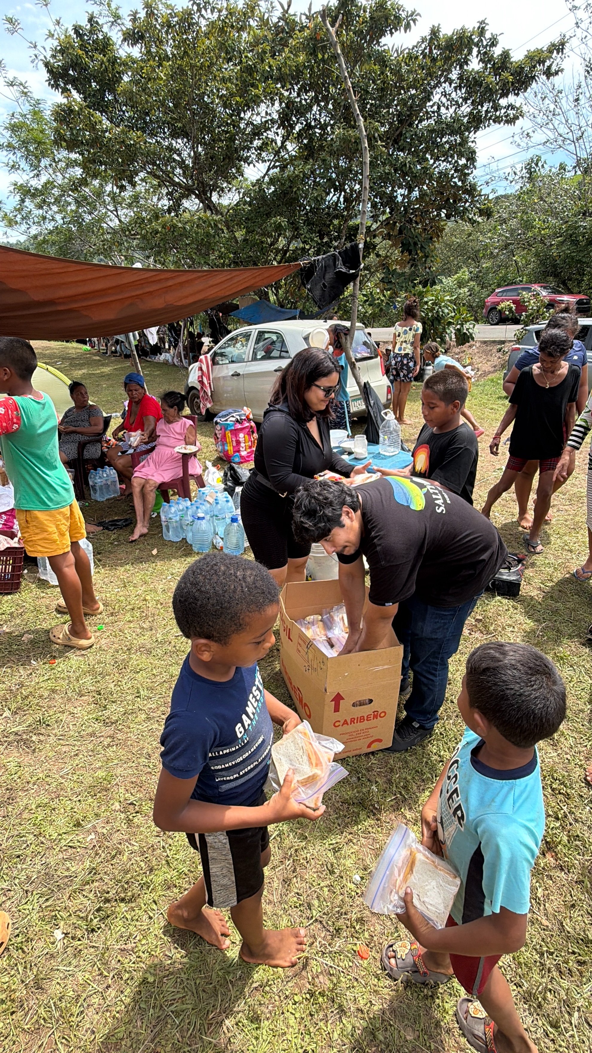 Voluntarios entregando sándwiches y agua a niños y familias afectadas por el terremoto